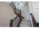 A staircase features carpeted steps and a dark wood railing against a light gray wall with an open space niche at 12964 Walbeck Dr, Fishers, IN 46037