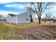 Backyard view of the home, with a neutral siding, mature trees, and view of surrounding homes at 1818 Arlene Dr, Indianapolis, IN 46219