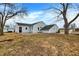Backyard view of the home, with a well-maintained yard, mature trees, and a neutral siding at 1818 Arlene Dr, Indianapolis, IN 46219