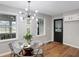 Dining area featuring modern light fixture, glass-top table with chairs and access to the kitchen at 1818 Arlene Dr, Indianapolis, IN 46219
