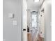 Hallway with hardwood floors leading to a tiled bathroom with modern finishes at 1818 Arlene Dr, Indianapolis, IN 46219