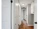 Hallway featuring hardwood floors, white trim, and neutral gray walls at 1818 Arlene Dr, Indianapolis, IN 46219