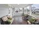 Bright sunroom with multiple windows, wood-look flooring, neutral paint, and cozy seating arrangements at 1818 Arlene Dr, Indianapolis, IN 46219