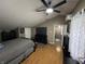 Bedroom with hardwood floor, black furniture set, ceiling fan and TV with a view to the bathroom at 1905 Apple St, Greenfield, IN 46140