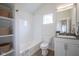 Bright bathroom featuring subway tile shower/tub, floating shelves, and white cabinets at 206 N Hamilton Ave, Indianapolis, IN 46201