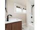Well-lit bathroom features a shower, tub combo with marble-style tile, and a wood vanity with double sinks at 2110 N Talbott St, Indianapolis, IN 46202