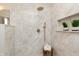 Spacious shower with marble-style tile, rainfall showerhead, built-in niche, and a wooden stool with towels at 2110 N Talbott St, Indianapolis, IN 46202