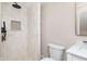 Bathroom featuring a white vanity, matching toilet, and a tiled shower with shelves at 2110 N Talbott St, Indianapolis, IN 46202