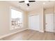 Bright bedroom featuring a large window, neutral walls, ceiling fan, and light hardwood floors at 2110 N Talbott St, Indianapolis, IN 46202