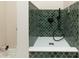 Modern shower with unique green tile, matte black fixtures, and a white base at 2110 N Talbott St, Indianapolis, IN 46202