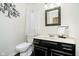 Bathroom featuring a white toilet, black vanity, and decorative mirror at 21360 Oakview Dr, Noblesville, IN 46062