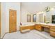 Bright bathroom with a large tub, wooden cabinets, and vanity, promoting relaxation and style at 21360 Oakview Dr, Noblesville, IN 46062