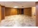 Finished basement space with paneled walls, tile flooring, and access to bathroom at 3233 E 48Th St, Indianapolis, IN 46205