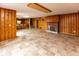 Spacious basement area with wood paneled walls, tile flooring, bar, and a fireplace at 3233 E 48Th St, Indianapolis, IN 46205