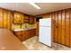 Basement kitchenette with paneled walls, sink, cabinets, countertop, and refrigerator at 3233 E 48Th St, Indianapolis, IN 46205