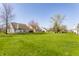 Expansive backyard view showcasing lush green lawn and neighboring houses with mature trees at 3841 Constitution Dr, Carmel, IN 46032