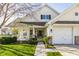 Inviting home featuring a two-car garage, front porch, manicured lawn, and charming architectural details at 3841 Constitution Dr, Carmel, IN 46032
