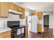 Well-lit kitchen featuring wood cabinets, black appliances, and modern white refrigerator at 3841 Constitution Dr, Carmel, IN 46032