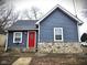 Charming home featuring blue siding, stone accents, a bright red door and well-maintained landscaping at 422 Johnson Ave, Franklin, IN 46131