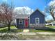 Charming blue home with stone accents, bright red door, and a well-maintained front yard under a sunny blue sky at 422 Johnson Ave, Franklin, IN 46131