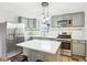 The renovated kitchen features grey cabinetry, stainless steel appliances, white countertops, and kitchen island at 455 Meadowview Ln, Greenwood, IN 46142