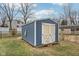 A blue and white storage shed with double doors sits in the backyard at 455 Meadowview Ln, Greenwood, IN 46142