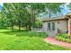 Lush backyard featuring a deck, mature trees, green grass and a brick pathway at 502 Ironwood Dr, Carmel, IN 46033