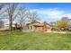 The backyard features a large grassy area, mature trees, and a deck, offering plenty of space for outdoor activities at 502 Ironwood Dr, Carmel, IN 46033