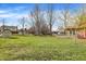 Lush backyard featuring a well-manicured lawn, storage shed, mature trees, and a cozy deck for outdoor relaxation at 502 Ironwood Dr, Carmel, IN 46033