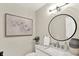 Bathroom area features a modern mirror, a white sink and vanity and modern art at 502 Ironwood Dr, Carmel, IN 46033