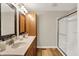 Bathroom featuring double sinks, wood cabinets, and a glass-enclosed shower at 502 Ironwood Dr, Carmel, IN 46033