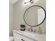Bathroom with a round mirror, a white marble countertop, and a decorative houseplant at 502 Ironwood Dr, Carmel, IN 46033