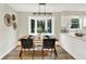 Bright dining area with modern light fixture, seating for four and view to the kitchen at 502 Ironwood Dr, Carmel, IN 46033