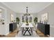 Formal dining room boasts ample seating, large windows, and a stylish chandelier at 502 Ironwood Dr, Carmel, IN 46033