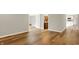 Open hallway view showcasing hardwood floors, a bathroom, and a glimpse into the kitchen at 502 Ironwood Dr, Carmel, IN 46033