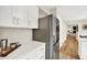 Kitchen area with stainless steel appliances, white cabinets and wood flooring at 502 Ironwood Dr, Carmel, IN 46033