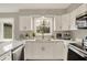 Well-lit kitchen with white cabinets, stainless steel appliances, marble countertops, and a large window at 502 Ironwood Dr, Carmel, IN 46033