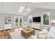 Living room with vaulted ceilings, skylights, and french doors leading to the backyard at 502 Ironwood Dr, Carmel, IN 46033