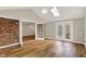 Open living space features hardwood floors, brick accent wall, and access to an outdoor patio at 502 Ironwood Dr, Carmel, IN 46033