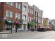 Urban streetscape with brick buildings, bike parking, hanging flower baskets, cafes, and outdoor seating at 502 Ironwood Dr, Carmel, IN 46033