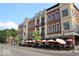 Street view of multiple storied buildings with patios, umbrellas, and outdoor dining options available at 502 Ironwood Dr, Carmel, IN 46033