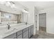 Bathroom features a gray vanity with double sinks, modern fixtures, and large mirror; shower in the background at 5421 Landing Place Ln, Noblesville, IN 46062
