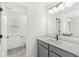 Well-lit bathroom vanity featuring gray cabinets, a modern faucet, a large mirror, and access to toilet at 5421 Landing Place Ln, Noblesville, IN 46062