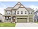 Charming two-story home with three-car garage, and well-manicured lawn on a sunny day at 5421 Landing Place Ln, Noblesville, IN 46062