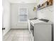 Laundry room equipped with washer, dryer, and storage shelf; tiled flooring at 5421 Landing Place Ln, Noblesville, IN 46062