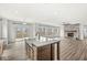 Open-concept living room with island, fireplace, hardwood floors and sliding door to deck at 5421 Landing Place Ln, Noblesville, IN 46062