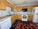 Functional kitchen featuring wood cabinetry and white appliances at 5451 Kelvington Ln, Indianapolis, IN 46254