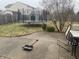 Backyard featuring a trampoline, shed, grass, and a patio with chairs, and a shovel on the ground at 5801 Safari Dr, Indianapolis, IN 46237