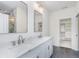 Elegant bathroom with double sink, white cabinets, stone countertops and access to closet at 5862 Harbour Town Dr, Noblesville, IN 46062