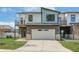 Contemporary townhome featuring a two-car garage, stone veneer, and a combination of white and blue-grey siding at 5862 Harbour Town Dr, Noblesville, IN 46062